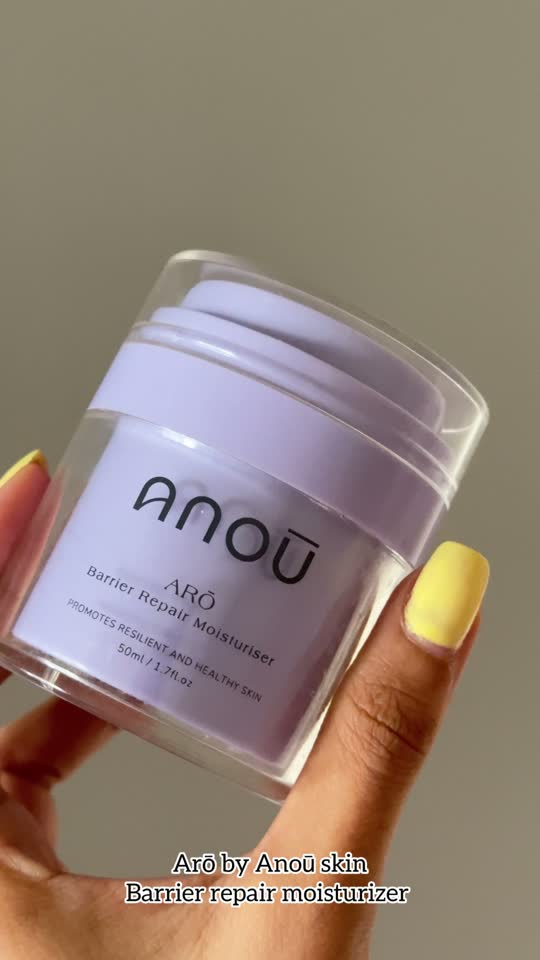 Video still of a hand with yellow nails holding the lilac Arō jar; the caption names Arō Barrier Repair Moisturiser.