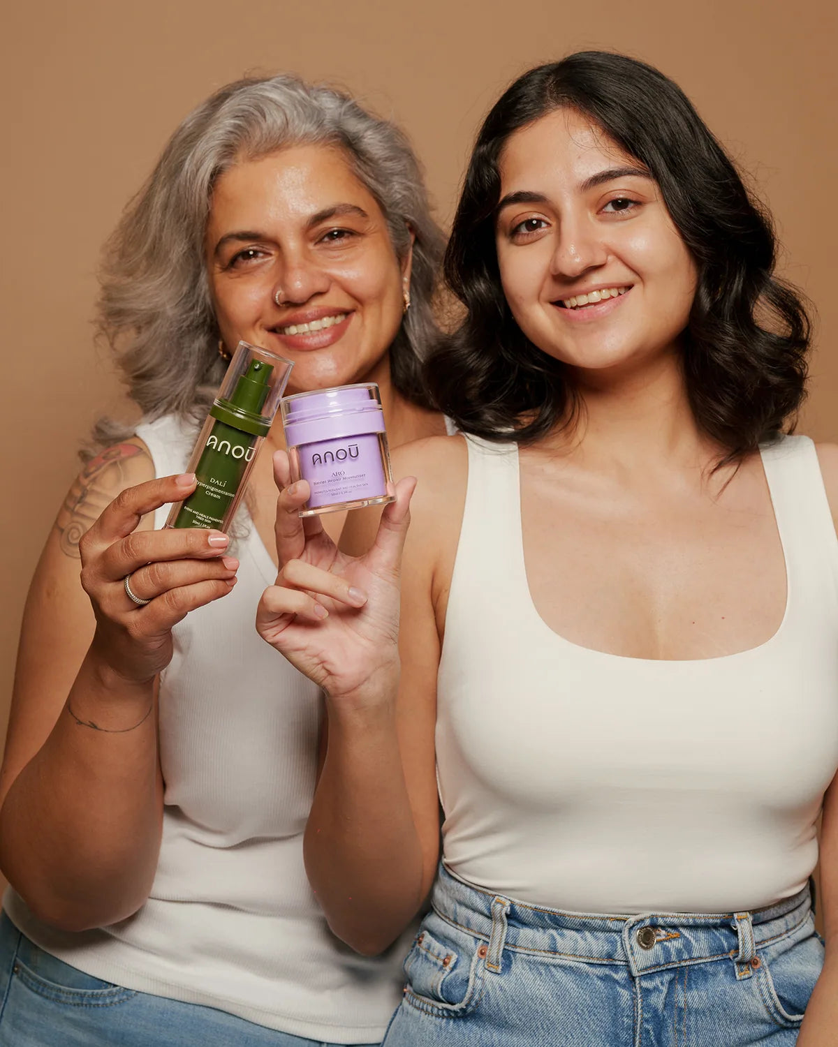 Two people holding Anoū Arō and Dalí products